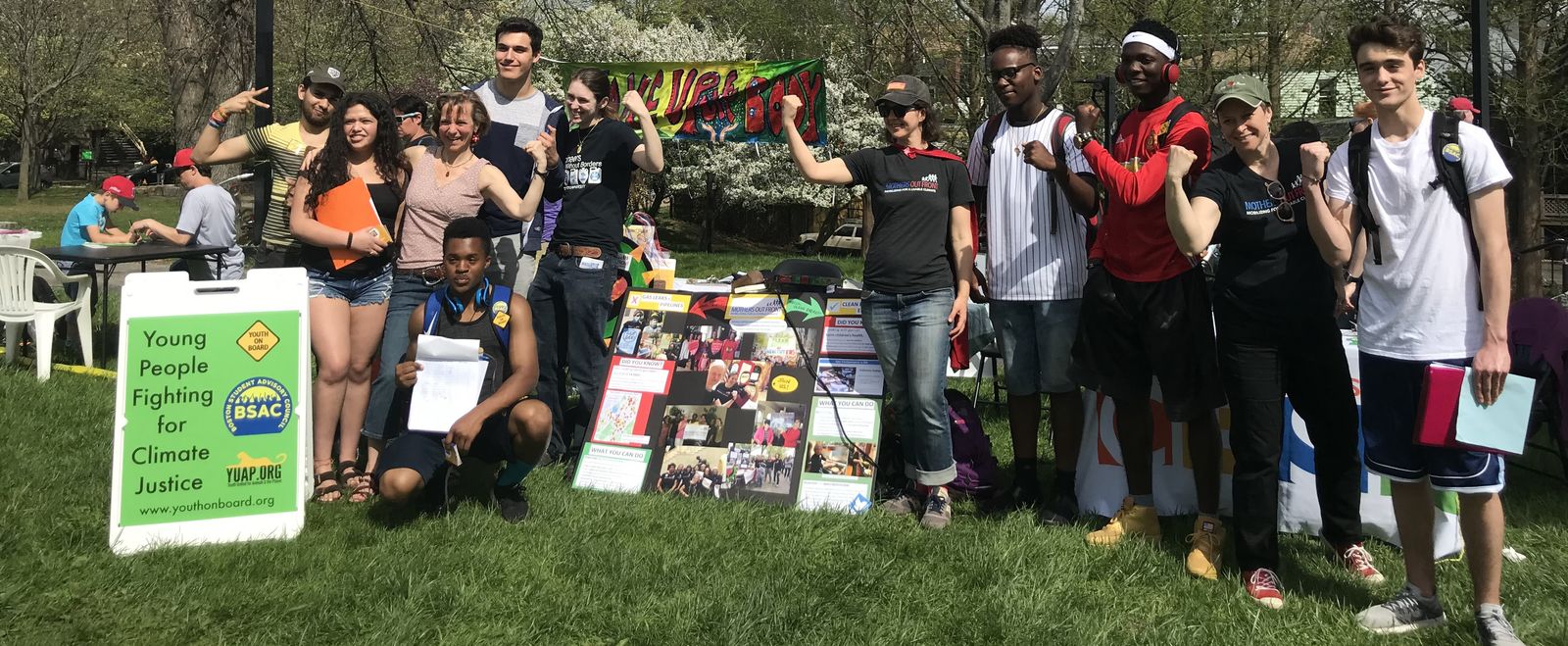 Activists raise their fists at an outdoors festival.