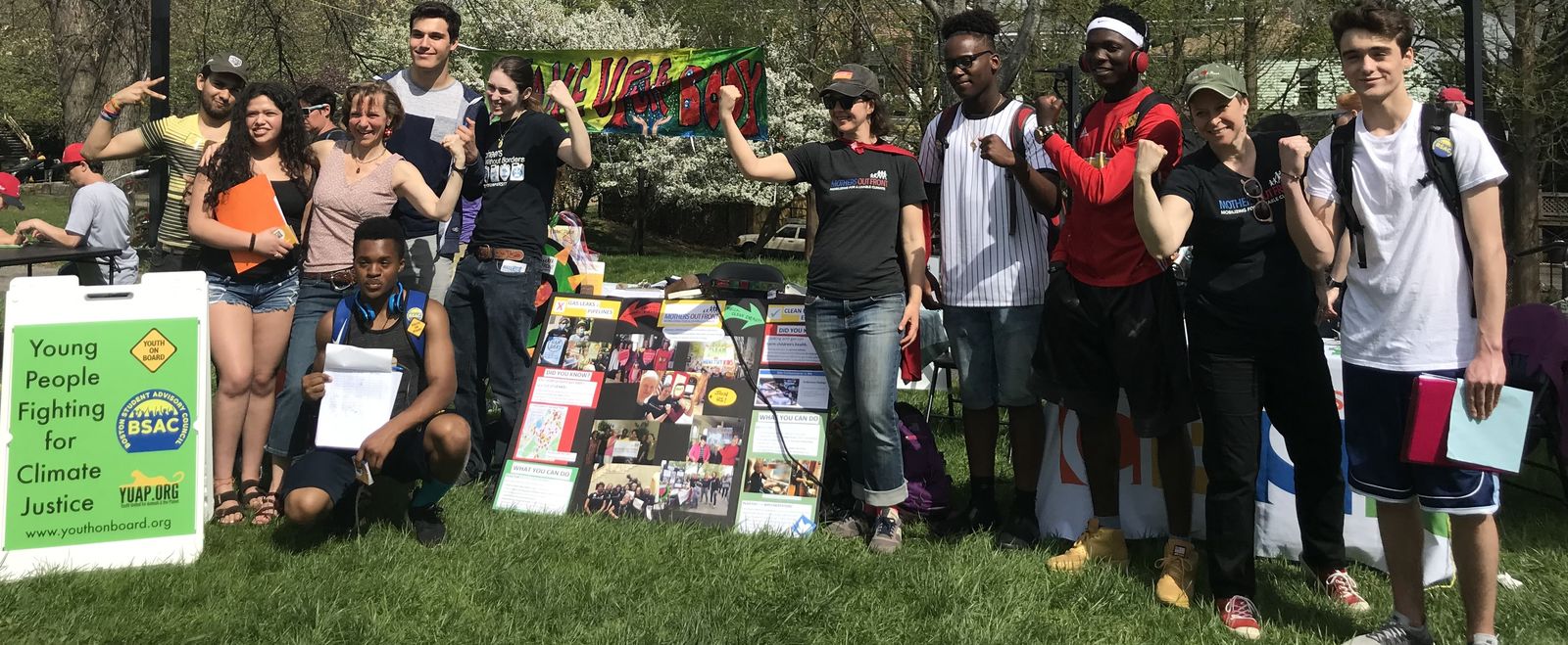 Activists raise their fists at an outdoors festival.